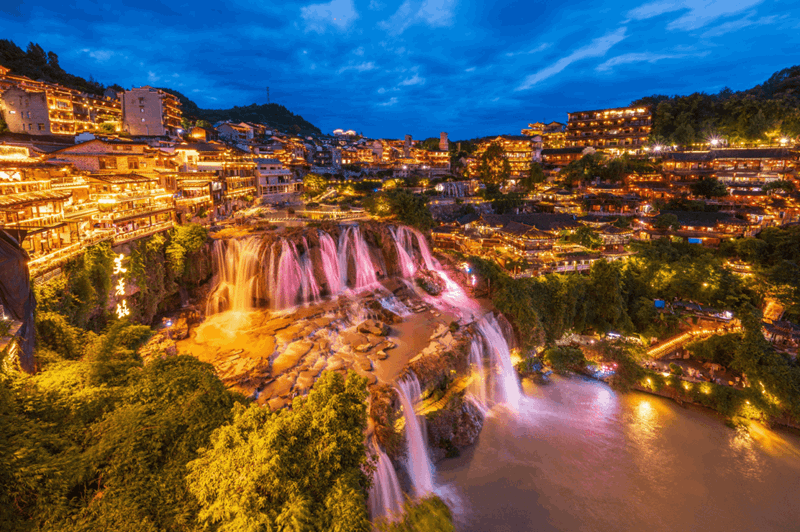 The spectacular view of the waterfalls of Furong ancient town in China during the night time