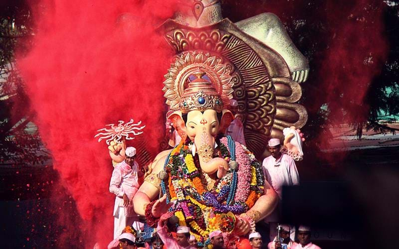 A statue of Ganesh is paraded through the streets during a colourful monsoon festival