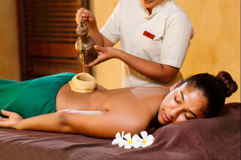 A woman enjoying an Ayurvedic treatment with oil