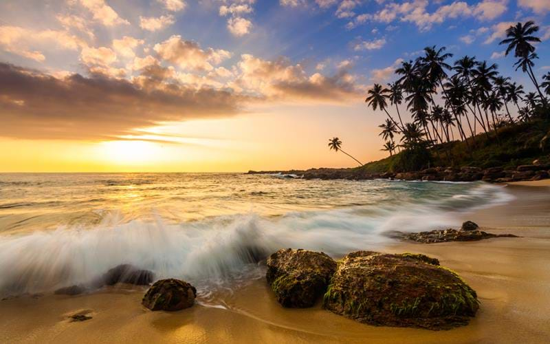 Tropical sandy beach at sunset in Sri Lanka - a great Christmas destination in Asia